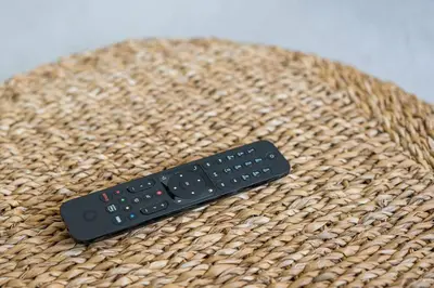 a remote control sitting on top of a straw hat at Porto Paraíso Right by RDC in Porto