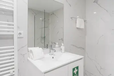 a white bathroom with a sink and a mirror at Porto Paraíso Right by RDC in Porto