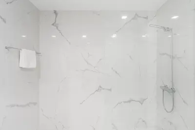 a bathroom with a shower with white marble walls at Porto Paraíso Right by RDC in Porto