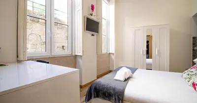 a bedroom with a white bed and a sink at Casa do Recanto - Studio in Porto