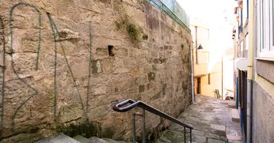 an alley with a stone wall with a hand rail at Casa do Recanto - Studio in Porto