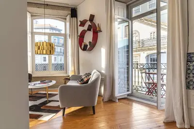 a living room with a chair and a table at Mouzinho Penthouse by Hosty in Porto