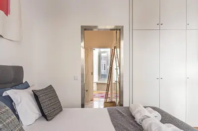 a bedroom with a bed and a door into a room at Mouzinho Penthouse by Hosty in Porto