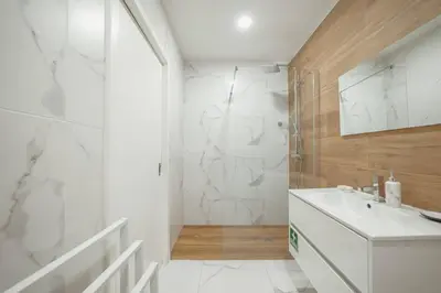 a white bathroom with a shower and a sink at Coliseu Apartment by Hosty in Porto