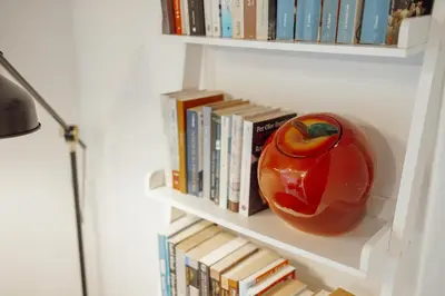 a book shelf with a toy apple and books at OPORTO GUEST Luxus Garden in Porto