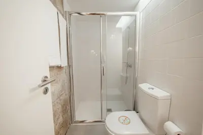 a white bathroom with a shower and a toilet at OPORTO GUEST Luxus Garden in Porto
