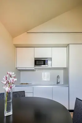 a kitchen with a table with a vase of flowers at PATH Bonjardim Apartments in Porto