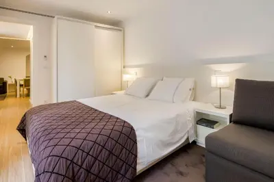 a bedroom with a large white bed and a couch at PATH Bonjardim Apartments in Porto