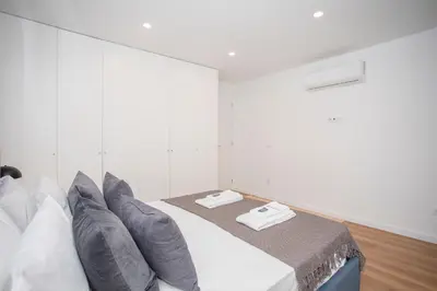 a white room with a bed with pillows at NAX Apartments by Liiiving in Porto