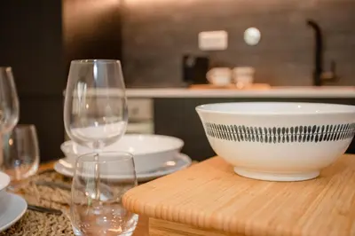 a table with a bowl and wine glasses on it at NAX Apartments by Liiiving in Porto