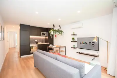 a living room with a couch and a tv on a wall at NAX Apartments by Liiiving in Porto