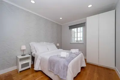 a white bedroom with a bed and a window at Casinha dos Avós by LovelyStay in Vila Nova de Gaia