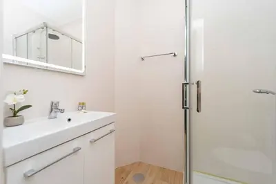 a white bathroom with a sink and a shower at Casinha dos Avós by LovelyStay in Vila Nova de Gaia