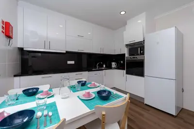 a kitchen with white cabinets and a table with bowls on it at Casinha dos Avós by LovelyStay in Vila Nova de Gaia
