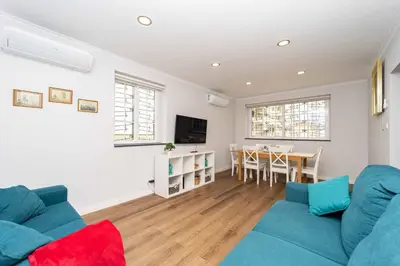 a living room with a blue couch and a table at Casinha dos Avós by LovelyStay in Vila Nova de Gaia