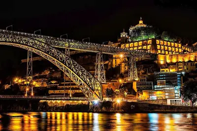 a bridge over a river at night with a building at Casinha dos Avós by LovelyStay in Vila Nova de Gaia