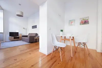 a white living room with a table and chairs at Citybreak-apartments Sao Bento in Porto