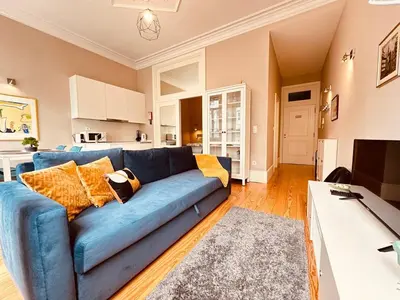 a living room with a blue couch and a kitchen at Art Magellan in Porto