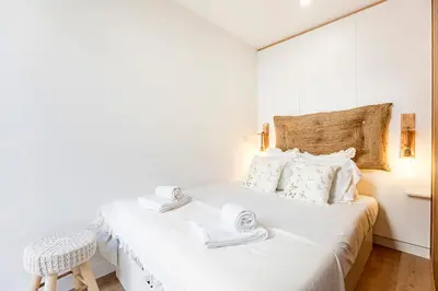 a white bedroom with a bed with towels on it at Villa Terra The Garden in Vila Nova de Gaia