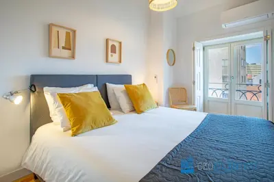 a bedroom with a large bed with yellow pillows at Poveiros Oak Loft - Santo Ildefonso in Porto