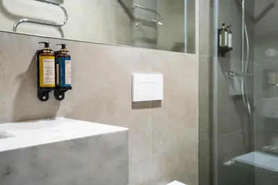a bathroom with a shower with two fire extinguishers on the wall at Sta Catarina 632 by LovelyStay in Porto