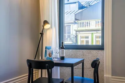 a table with a bottle of wine and a window at Sta Catarina 632 by LovelyStay in Porto