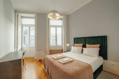 a white bedroom with a large bed with a table at Formosa Deluxe by Hosty in Porto