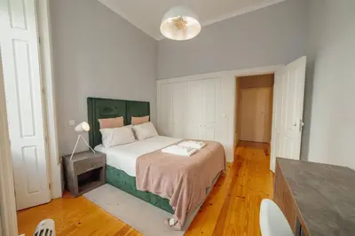 a bedroom with a bed with a green headboard at Formosa Deluxe by Hosty in Porto