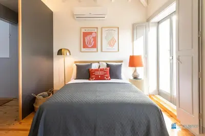 a bedroom with a large bed with red pillows at Boavista Charm Balcony Loft in Porto