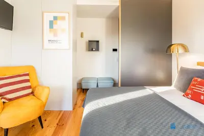 a bedroom with a bed and a chair at Boavista Charm Balcony Loft in Porto