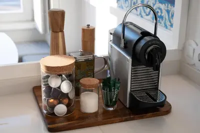 a kitchen counter with a coffee maker on a wooden stand at Quadra Apartment - Luxury & Relaxation in Porto