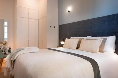 a bedroom with a large bed with a large headboard at Quadra Apartment - Luxury & Relaxation in Porto