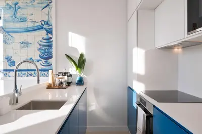 a kitchen with blue and white cabinets and a sink at Quadra Apartment - Luxury & Relaxation in Porto