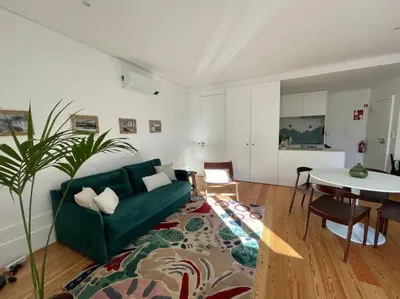 a living room with a green couch and a table at Apartment with balcony in the center of Porto in Porto