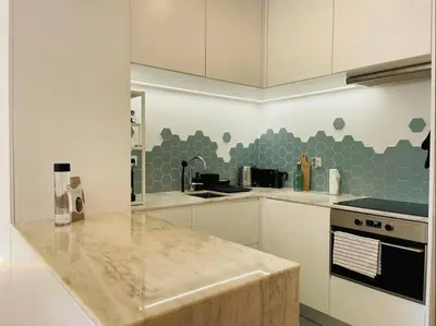 a kitchen with white cabinets and a counter top at Apartment with balcony in the center of Porto in Porto