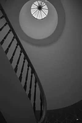 a spiral staircase with a round window on the ceiling at Apartment with balcony in the center of Porto in Porto