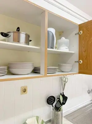 a kitchen cabinet with plates and utensils in it at Oporto Music Flat - Very Central & Free Parking in Porto