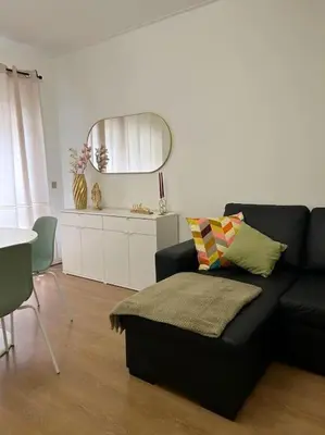 a living room with a black couch and a mirror at Oporto Music Flat - Very Central & Free Parking in Porto