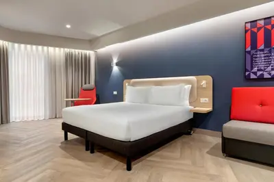 a bedroom with a bed and a chair at Holiday Inn Express Porto - Boavista by IHG in Porto