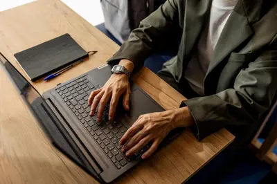 a person typing on a laptop computer on a table at Holiday Inn Express Porto - Boavista by IHG in Porto