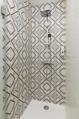 a bathroom with a shower with a tiled wall at Clérigos Apartments Porto - Premium in Porto