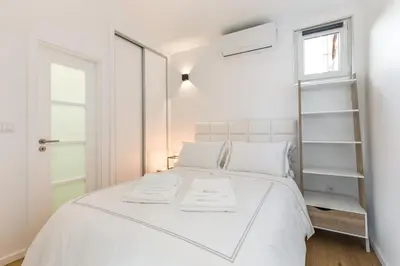 a white bedroom with a white bed and a window at Clérigos Apartments Porto - Premium in Porto
