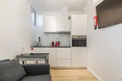 a kitchen with a couch and a table in a room at Clérigos Apartments Porto - Premium in Porto