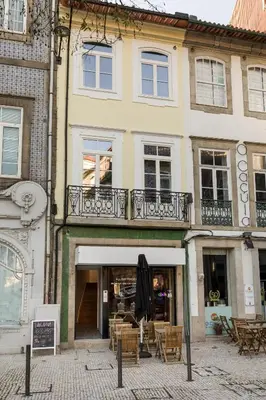 a building with a balcony and tables and chairs at Clérigos Apartments Porto - Premium in Porto