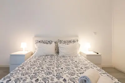 a bedroom with a large bed with two lamps at Moreira Terrace in Porto