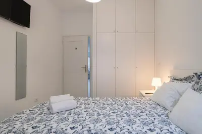 a bedroom with a bed with a blue and white blanket at Moreira Terrace in Porto