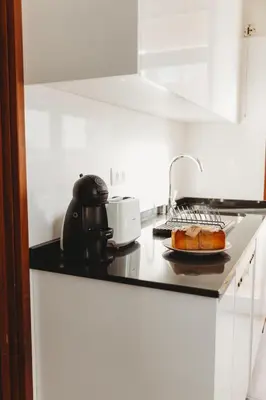 a kitchen counter with a sink and a plate of bread at Apartamento Santos Pousada 2 in Porto
