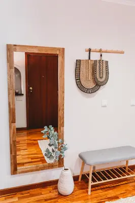 a mirror in a room with a bench and a table at Apartamento Santos Pousada 2 in Porto