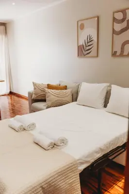 two beds in a living room with a couch at Apartamento Santos Pousada 2 in Porto