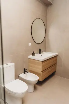 a bathroom with a toilet and a sink and a mirror at Apartamento Santos Pousada 2 in Porto
